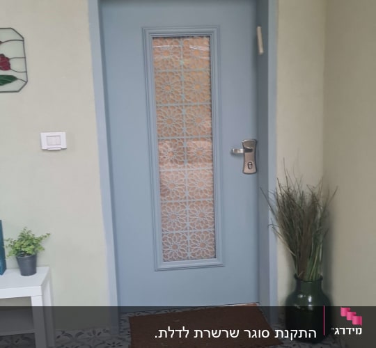 דלת כניסה מעוצבת בצבע תכלת-אפור עם חלון זכוכית מעוטר